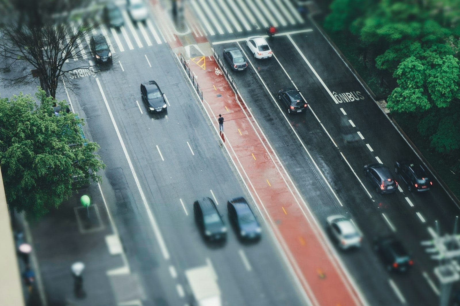 Avenida vista de cima com faixa de ônibus vermelha e carros