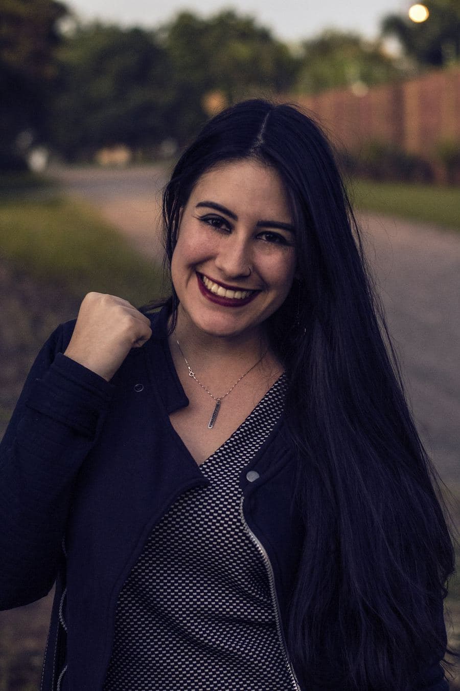 Mulher de cabelo preto longo sorrindo para a câmera